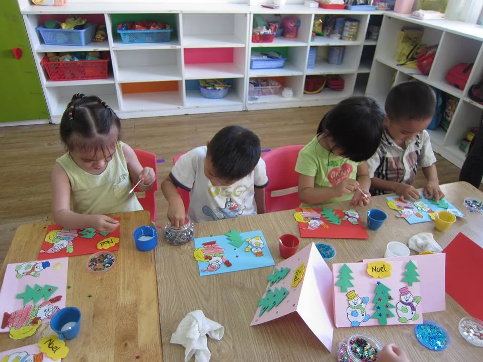 Hình ảnh các em học sinh đang hăng say thiết kế thiệp trang trí noel lớp học